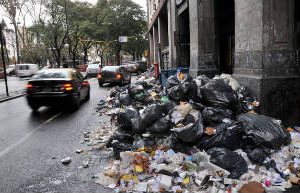La Ciudad:Bajo la lluvia  y entre basura.